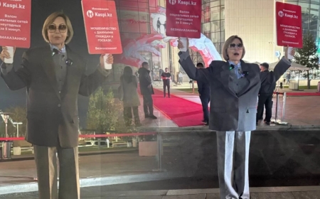 Orda.kz сайтының бас редакторы Гүлнәр Бажкенова Kaspi банк алдында пикет өткізді